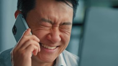 Mutlu duygusal işadamı Asyalı Çinli Çinli Japon adam şirketi kurucusu ofiste çalışan yetişkin bir adamın cep telefonu konuşmasında cep telefonuyla 5G bağlantısı cep telefonuyla iş görüşmesi