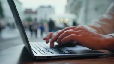 Yakından erkek eller dizüstü bilgisayarcı serbest yazar. Kafede uzaktan çalışan bir iş adamı. Bilgisayar teknolojisini internet üzerinden seyahat bileti almak ya da çalışmak için kullanır.