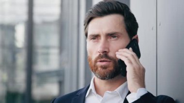 Cep telefonuyla konuşan ciddi bir adamın portresi. İş görüşmeleri. Başarılı iş adamı, profesyonel yönetici danışman.