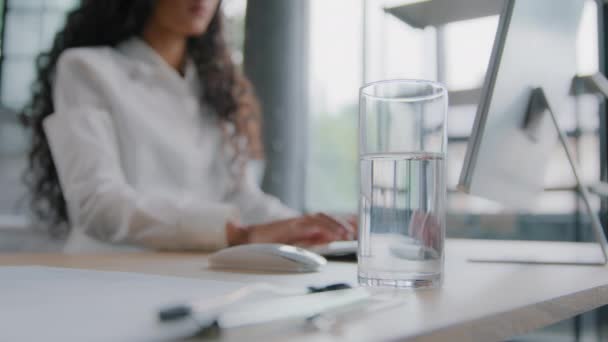 Blurred Viewコンピュータでオフィスで働く認識できない女性忙しいビジネス女性キーボードのプロのマネージャーを入力すると デスクトップ上の水スタンドのガラスにインターネットのクローズアップフォーカスにリモートで動作します — ストック動画