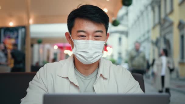 보호용 마스크를 미소짓는 남자는 컴퓨터 미디어에서 친구와 대화를 나누고 — 비디오