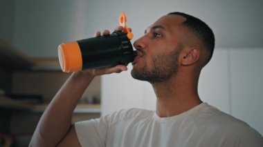 Kapalı Afrikalı Amerikalı sporcu vücut geliştirme sporcusu erkek milkshake 'den sabah su içiyor sıvı kalsiyum vitaminler protein besleyici takviyeler su dengesi kilo verme bakımı