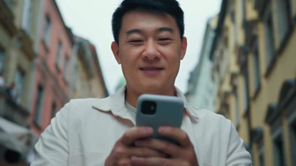 Yakın Plan Mutlu Asyalı Erkek Turist Elinde Cep Telefonuyla Geziyor — Stok video