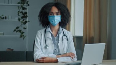Tıbbi koruyucu maskeli Afrikalı kadın doktor, hemşire, psikolog, klinik hastanesinde oturan pratisyen hekimler viral koronavirüs salgınını önlediler.