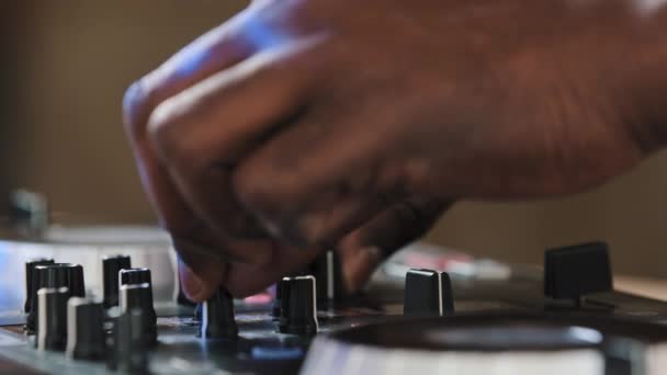 非洲Dj手拉手在夜总会派对上演奏音乐在混音板上混合舞蹈节奏在节日期间创造音乐能量表演场景扭曲按钮增加音量使用音效 — 图库视频影像