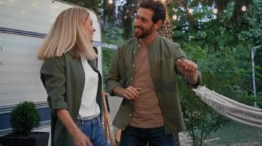 Arka bahçede dans eden komik bir çift Kafkasyalı neşeli kadın ve yetişkin sakallı adam mutlu eşlerle evlendi. Karı koca, minibüsün yanında dans ediyorlar.