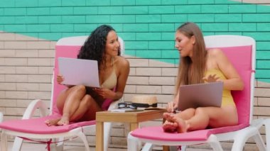 Genç bayan modeller beş arkadaşlık jesti yapıyor etnik Kafkas ve İspanyol kızlar yaz tatilinde serbest çalışıyorlar otel wifi ile internet haberlerini kutluyorlar