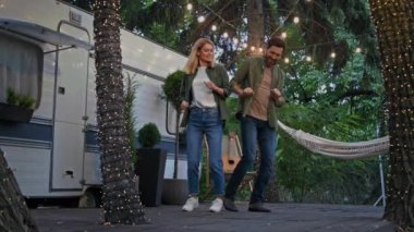 Kamp yapan beyaz bir çift. Elleriyle hareket ediyor. Açık havada müzik çalıyor. Kamp yerinde dans eden komik dansçılar eşleriyle balayı seyahatini kutluyor.