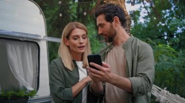 Evli karı koca, beyaz sakallı erkek ve kadın 40 'lı yaşlarda erkek ve kız arkadaş yürüyorlar cep telefonlu akıllı telefonlara bakıyorlar açık hava kamplarında internet üzerinden yürüyüş yapıyorlar.