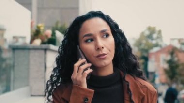30 'lu yaşlarda Latin bir iş kadını. Kadın girişimci. Şehirde yürüyen, telefonla konuşan, konuşan, dışarıda konuşan, cep telefonu konuşmaları yapan, uzaktan kumandalı.