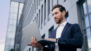 Başarılı iş adamı geliştirici dizüstü bilgisayarla yazı yazarak yeni bir başlangıç planı oluşturdu. Açık havada çalışan, bilgisayar uygulaması kullanarak internet üzerinde strateji geliştiren bir adam yarattı.