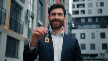 Emlak yöneticisi ev sahibi işadamı bankacı Kafkasyalı başarılı adam şehir merkezindeki yeni apartman dairesinin anahtarlarını satıyor inşaat ticareti ticari iş anlaşması.
