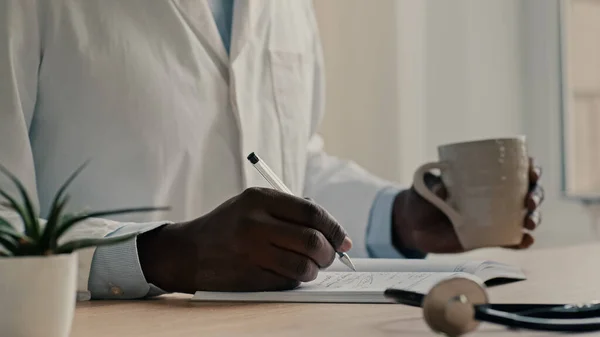 Männlich Arzt Medizinischem Mantel Sitzen Der Klinik Halten Stift Schreiben — Stockfoto
