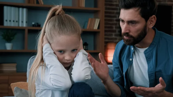 Sad offended little child daughter feel stress cover ears ignoring scream caucasian angry annoyed man dad shouting on girl for bad behavior and disobedience scolding kid problem of parenting in family
