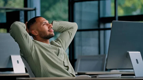African American business guy man office worker manager entrepreneur man businessman company CEO boss programmer takes break to relieve stress satisfied finish work relax holding hands behind head