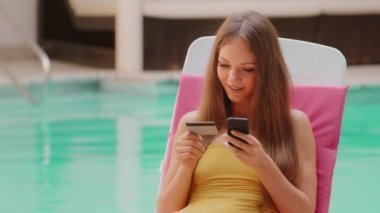 Mutlu Kafkas kadın müşteri alıcısı yaz tatillerinde akıllı telefon ve kredi kartı kullanıyor. İnternet üzerinden seyahat biletleri almak için cep telefonu ve kredi kartı kullanıyor.