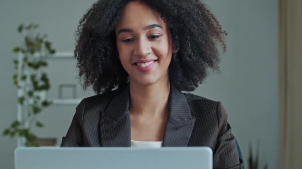アフリカのビジネス女性のオフィスの女性の労働者は オンラインチャットコールビデオ会議の仕事のインタビューでビジネスパートナーと話すラップトップの自宅のインターネットワークを使用します遠隔通信の専門家の交渉 — ストック動画