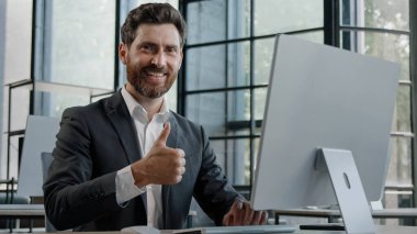 Orta yaşlı, sakallı, 40 'lı yaşlarda, ofiste bilgisayarla çalışan bir iş adamı. Menajer patron erkek şirket CEO 'su çevrimiçi çalışıyor. İşaret işareti onaylama jesti kabul edildi.