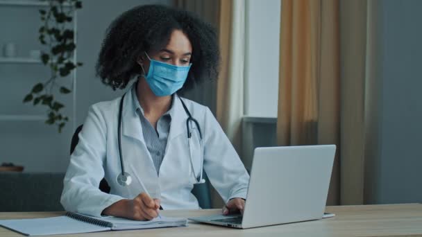 Mujer Africana Étnica Médico Terapeuta Cardiólogo Psicoterapeuta Máscara Médica Escribir — Vídeo de stock