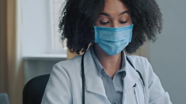マスク療法士の女性医師アフリカの女性医師は病気の男性を聞く病院のクリニックで患者の苦情は 錠剤ビタミンとボトルを与える薬の投与をお勧めします薬薬医学薬理学療法治療 — ストック動画