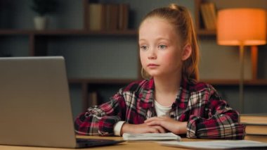 Güzel beyaz çocuk okul öğrencisi. Evden internet üzerinden ders çalışıyor. Bilgisayar dersi alıyor. Salgın hastalıklı izolasyon çocukları uzaktan eğitim programında sınıf arkadaşlarıyla video görüşmesi yapıyor.