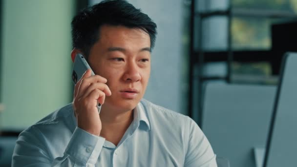 悲しいアジアの幹部労働者ビジネスマンマネージャー中年韓国人日本人中国人男性はオフィスでのモバイルコールの仕事に答える電話でビジネスの問題を解決遠くの会話によって5Gセル接続 — ストック動画