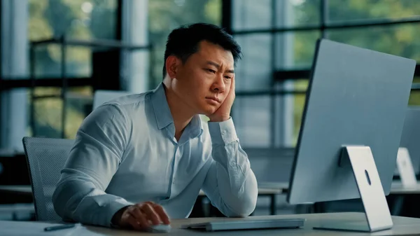 Bored lazy asian worker businessman korean japanese man exhausted weary male sit in office asleep tired from boring online work at computer develop business project unwell feeling lack of motivation