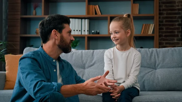 Caucasian man parent father psychologist talk to little cute kid girl teach small child of youth generation. Friendly dialogue with daughter at home parental support parenthood and fatherhood concept