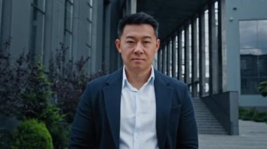 Kendine güvenen 40 'lı yaşlarda, Asyalı orta yaşlı iş adamı erkek şirket CEO' su avukat girişimci şehre doğru yürür ofis şirketinin yakınına koşar iş toplantısına koşar dışarı çıkar