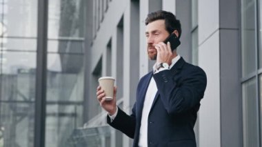 İdari işadamı danışman satış müdürü cep telefonuyla konuşuyor. Müşteri tavsiyesi veriyor. Pozitif adam dışarıda duruyor.