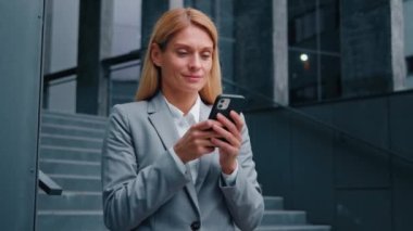 Cep telefonu tutan tatmin olmuş kadın internet üzerinden iyi haberler okuyor başarılı iş kadını lider profesyonel yönetici müşteri internet üzerinden sosyal ağ konseptini modern teknoloji kullanarak iletişim kuruyor
