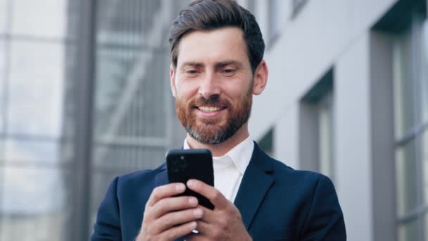 남자가 스마트폰을 사용하여 온라인상에서 주문을 이메일에 반응하는 성공적 사업가를 네트워크를 — 비디오