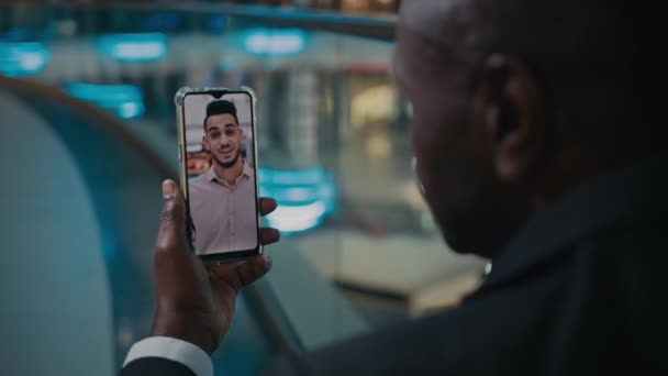 Powrót Podgląd Nierozpoznawalny Afroamerykanin Biznesmen Trzymający Telefon Mówiącym Indyjskim Etnicznym — Wideo stockowe