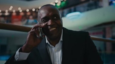 Gülümseyen, Afrikalı, yetişkin, olgun, yetişkin, yetişkin, çalışan, iş adamı, kapalı alanda çalışan, cep telefonu, uzaktan konuşma, gülücükler, şakalar, eğlence, gülücükler.