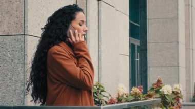 Ciddi Kafkasyalı İspanyol bayan bayan iş kadını yürüyor ev ofis terasında balkona çıkıyor cep telefonuyla konuşuyor uzaktan sanal konuşma konuşmaları, akıllı telefon konuşmaları.