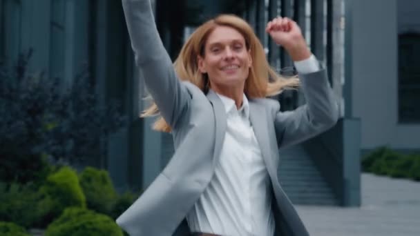 成功を祝う勝利の幸せな陽気なビジネス女性面白いジャンプ喜びオフィスビルの近くの屋外で勝者の喜びの女性ダンスは達成目標を達成勝利を祝う — ストック動画