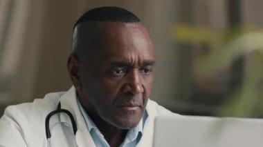 Afrikalı doktor psikoterapist. Hastanede çalışan pratisyen doktor. Laptop erkek terapist.