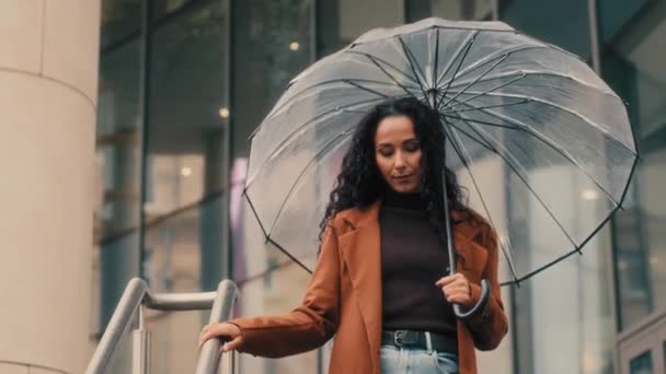 白种人女女女女女女女女商人带着透明的伞走楼梯靠近购物中心公司的办公楼在秋天下雨下雨天去商店 — 图库视频影像