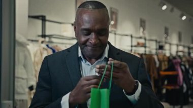 50 'li yaşlardaki Afrikalı orta yaşlı müşteri müşteri alıcısı iş adamı açık alışveriş torbası hediye paketi hasarlı, hayal kırıklığına uğramış, hayal kırıklığına uğramış tüketici kötü sipariş konusunda sorun yaşıyor.