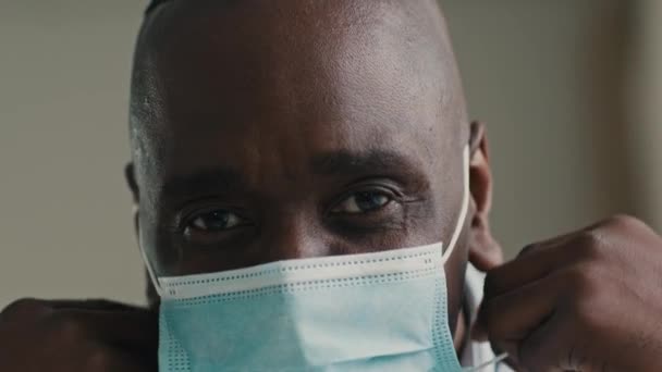 中国日报 的报道 非洲医生非洲裔男子专业外科医生在医院完成一天的工作摘下医疗面罩吸入新鲜空气深呼吸安全健康免受病毒感染预防流行病的爆发 — 图库视频影像