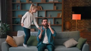 Sinirli baba işadamı evde telefonla konuşuyor. Cep telefonuyla görüşüyor. Sinir bozucu, zıplayan yaramaz kıza sakin olmasını söylüyor.