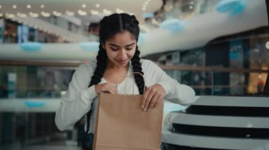 Memnun müşteri Arap güzel alışverişçi kız alışverişçi alışveriş kolik alışveriş mağazasından alışveriş giysileri satın alıyor bavulları açıyor sipariş alımlarından hoşlanan kadınların Kara Cuma 'da indirim kazanmasına şaşırıyor.