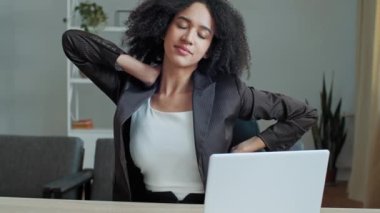 Yorgun, Afrikalı kadın iş kadını ofis masasında oturuyor bilgisayar işi sonrası kas gerilimi yorgunluğu, boyun masajı, omurga spazmı, sağlıklı vücut jimnastik gevşemesi.
