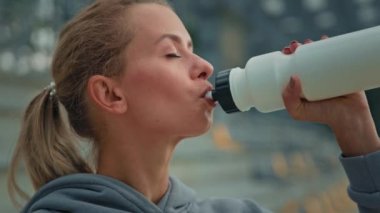 Sağlıklı kadın atletik kadın sporcu Kafkas kız koşucu koşucu bayan sporcu bayan sıcak su içiyor sportif gıda proteini enerji yaşam tarzı hidrasyon için şehir stadyumunda spor üstüne vücut.