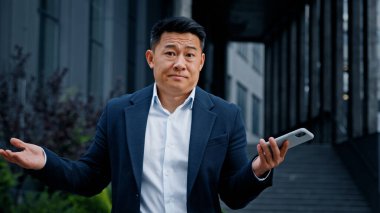 Şehirdeki Asyalı etnik işadamı telefonla sorun yaşıyor. Orta yaşlı CEO işveren dışarıda gezen bir girişimci bozuk bir hataya üzülüyor çevrimiçi cep telefonu bağlantısını kaybediyor