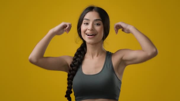 在黄色工作室背景下 印度裔成功女性女运动员运动女运动员运动健将模型展示大拇指合意的成功推荐支持理念好的手势 — 图库视频影像