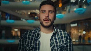 Umut dolu adam alışveriş merkezinde durup dua ediyor umut için dua ediyor iyi şanslar diliyor hayallerin başarıya odaklanmasını diliyor zafer için zafer isteyen Arap genç adam gözleri kapalı hayal kuruyor.
