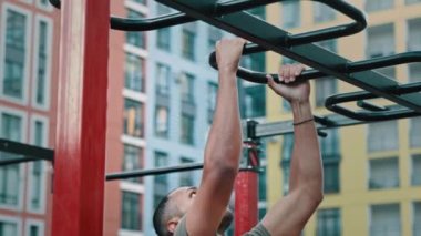 Güçlü atletik sporcu Latin Afrikalı Amerikalı vücut geliştirici yatay bar barfiks spor egzersizleri yapıyor açık havada spor salonunda kaslı vücut sporu sportif yaşam tarzı