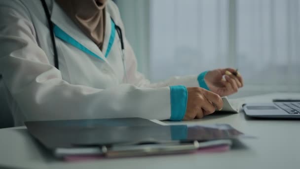 近视女医生全科医生护士妇女写治疗处方医疗笔记在纸面笔记本填写健康症状核对表或诊所的医疗保险工作 — 图库视频影像