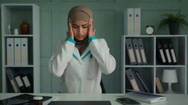 Hasta Arap Müslüman kadın, aşırı yüklenmiş, yorgun doktor doktor doktor, baş ağrısı, baş masajı şakakları, kronik migren hastalığı, hastanede aşırı çalışma nedeniyle rahatsızlıklar.